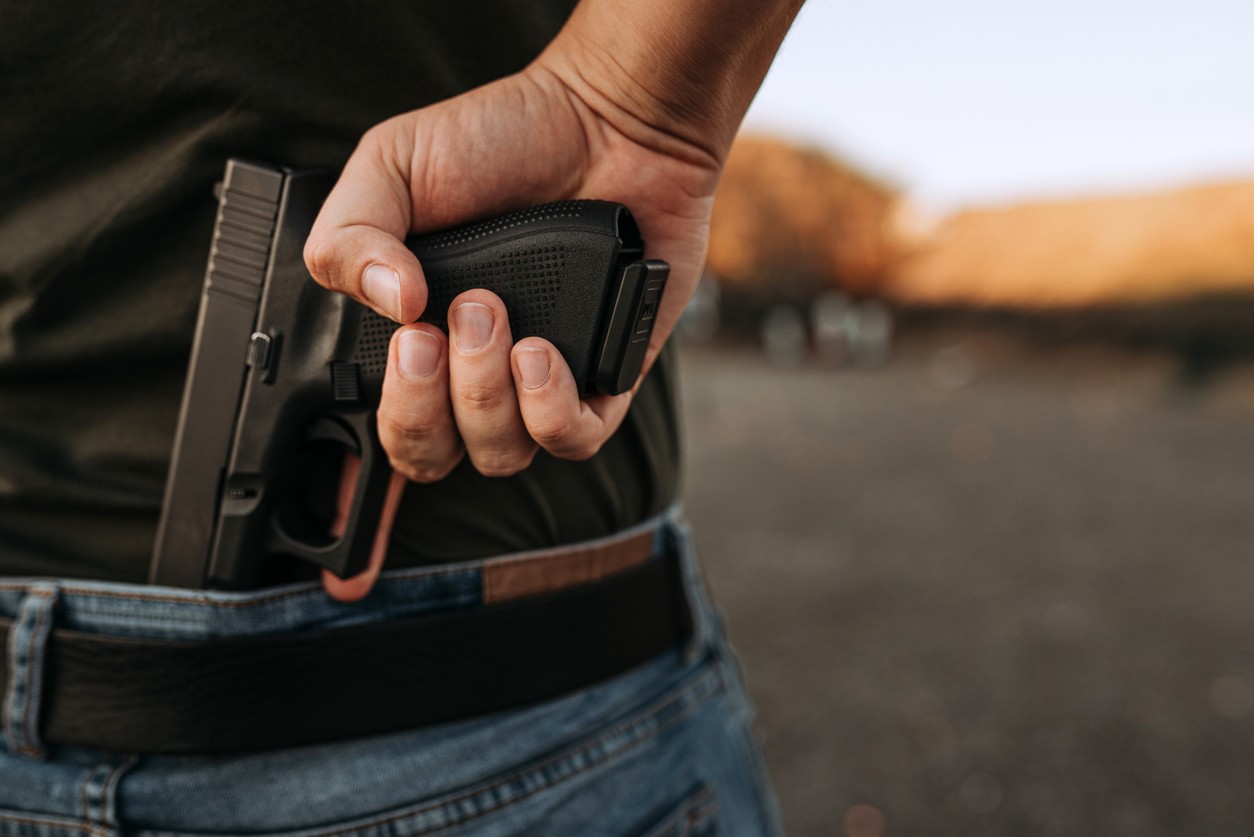 man-holding-gun-behind-back